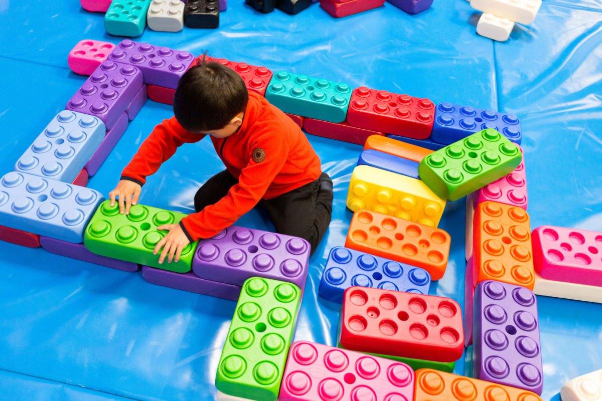 enfant qui joue au lego géant